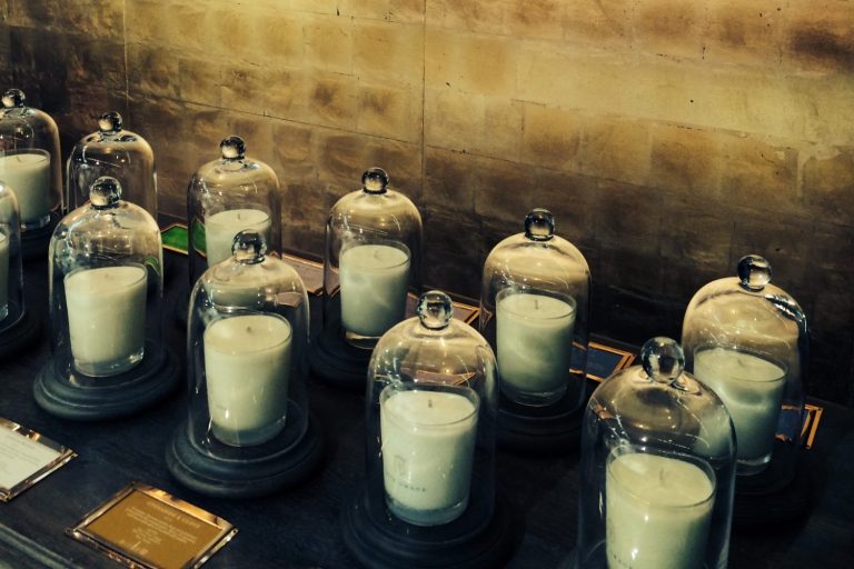 True Grace scented candles displayed under glass cloches against a gold-toned shop wall.